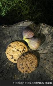 Figs and biscuits on wood. Green grass