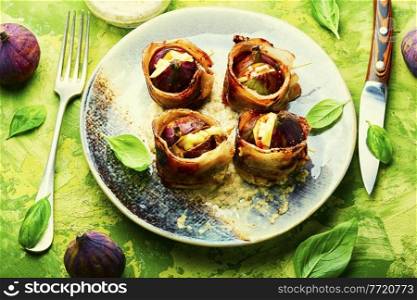Figs wrapped in fried bacon stuffed with cheese.Autumn food. Figs baked in bacon with cheese