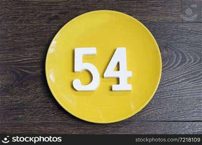 Figure fifty-four at the plate yellow and brown background.. The number fifty-four on the yellow plate.
