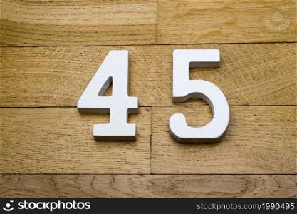 Figure forty-five on a wooden, parquet floor as a background.. Figure forty-five on the wooden, parquet floor.