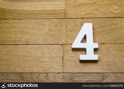 Figure four on a wooden, parquet floor as a background.. Number four on a wooden, parquet floor.