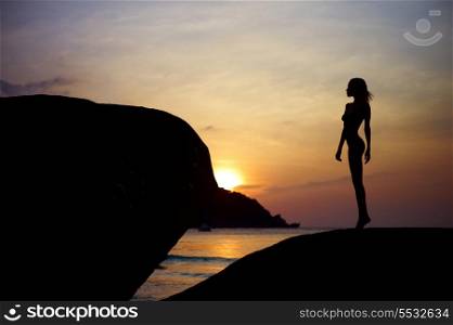 Figure of a girl in contre at sunset on the sea