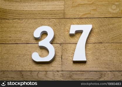 Figure thirty-seven on a wooden, parquet floor as a background.. Figure thirty-seven on a wooden, parquet floor.