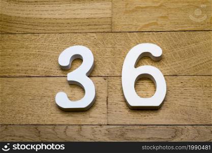 Figure thirty-six on a wooden, parquet floor as a background.. Figure thirty-six on a wooden, parquet floor.