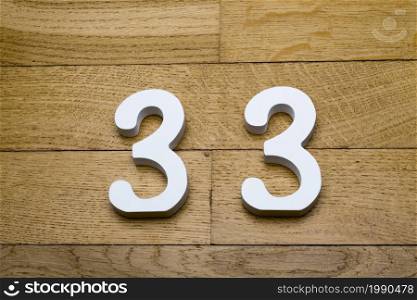 Figure thirty-three on a wooden, parquet floor as a background.. Figure thirty-three on a wooden, parquet floor.