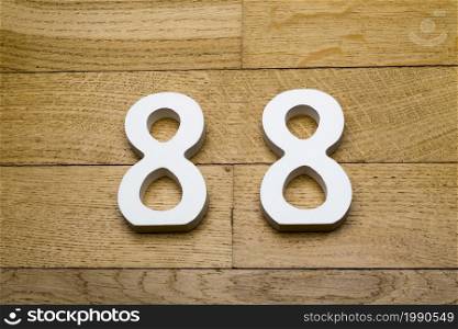 Figures eighty-eight on a wooden, parquet floor as a background.. Figures eighty-eight on the wooden, parquet floor.