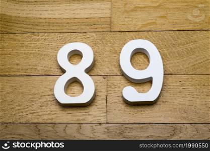 Figures eighty-nine on a wooden, parquet floor as a background.. Figures eighty-nine on the wooden, parquet floor.