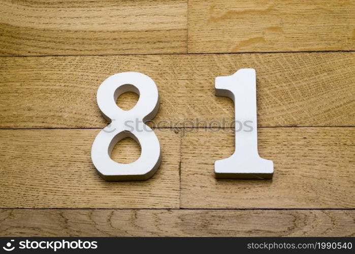 Figures eighty - one on the wooden, parquet floor as a background.. Figures eighty one on a wooden, parquet floor.