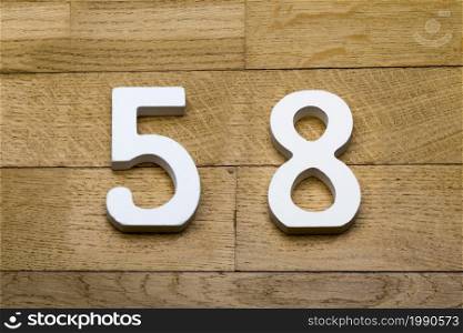 Figures fifty-eight on a wooden, parquet floor as a background.. Fifty-eight figures on the wooden parquet floor.