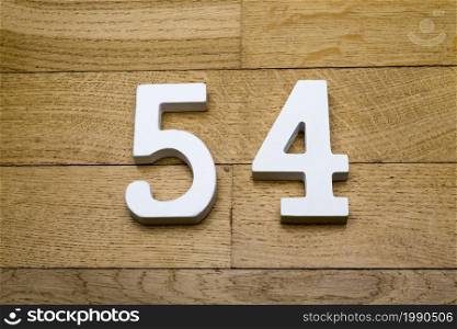 Figures fifty-four on a wooden, parquet floor as a background.. Fifty-four figures on a wooden parquet floor.