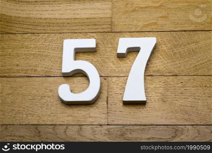 Figures fifty-seven on a wooden, parquet floor as a background.. Figures fifty seven on a wooden, parquet floor.