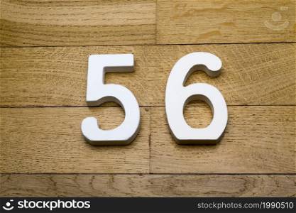 Figures fifty-six on a wooden, parquet floor as a background.. Figures fifty six on a wooden, parquet floor.