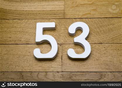 Figures fifty-three on a wooden, parquet floor as a background.. Fifty-three figures on a wooden parquet floor.