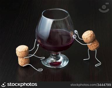 Figures from wine corks and a glass of wine