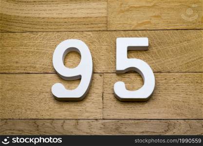 Figures ninety-five on a wooden parquet floor as a background.. Figures ninety-five on a wooden, parquet floor.