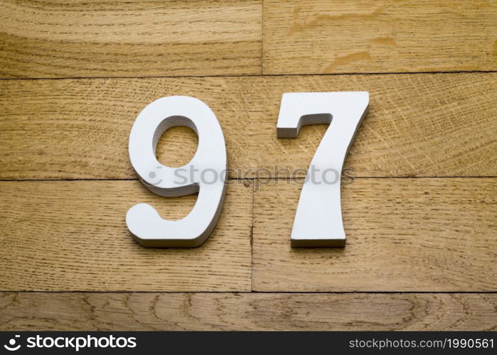 Figures ninety-seven on a wooden parquet floor as a background.. Figures ninety-seven on the wooden, parquet floor.