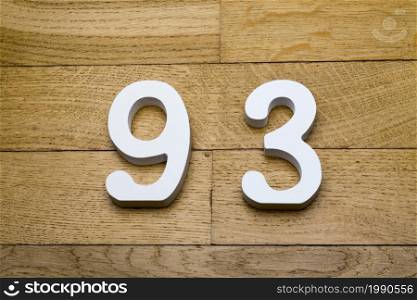Figures ninety-three on a wooden, parquet floor as a background.. Figures ninety-three on a wooden, parquet floor.