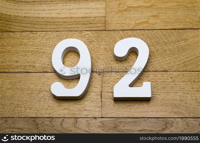 Figures ninety-two on a wooden, parquet floor as a background.. The figures are ninety-two on a wooden, parquet floor.