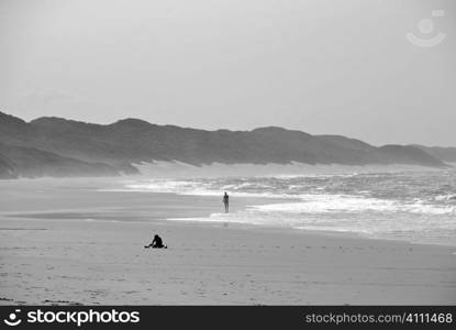 Figures on beach at water&acute;s edge in South Africa