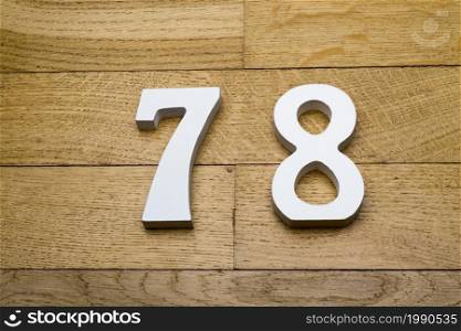Figures seventy-eight on a wooden, parquet floor as a background.. Figures seventy-eight on a wooden, parquet floor.