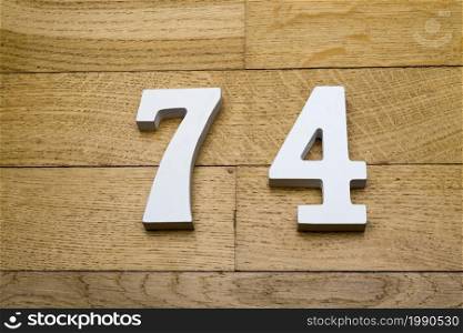 Figures seventy-four on a wooden, parquet floor as a background.. The figures are seventy-four on a wooden, parquet floor.