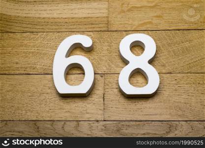 Figures sixty-eight on a wooden, parquet floor as a background.. Figures sixty-eight on a wooden, parquet floor.