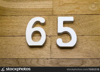 Figures sixty-five on a wooden, parquet floor as a background.. Figures sixty five on a wooden, parquet floor.