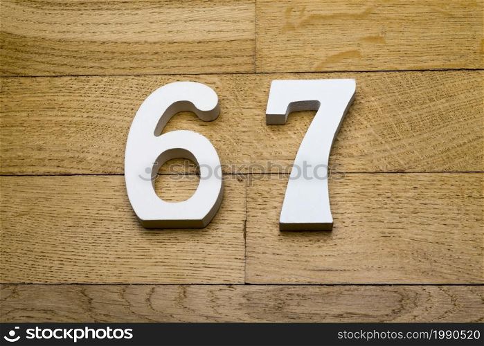Figures sixty-seven on the wooden, parquet floor as a background.. Figures sixty seven on the wooden, parquet floor.