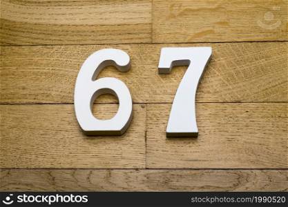 Figures sixty-seven on the wooden, parquet floor as a background.. Figures sixty seven on the wooden, parquet floor.