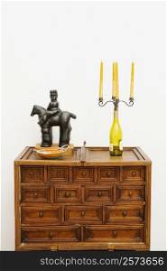 Figurine and a candlestick holder on a chest