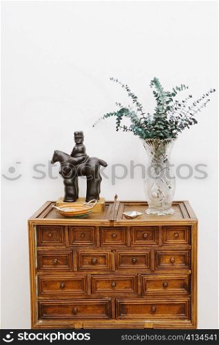 Figurine and a vase on a chest