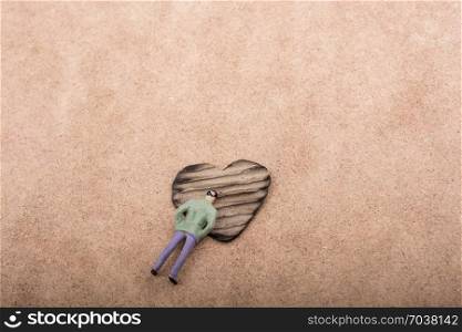 Figurine and Heart shaped burnt out of a brown cardboard