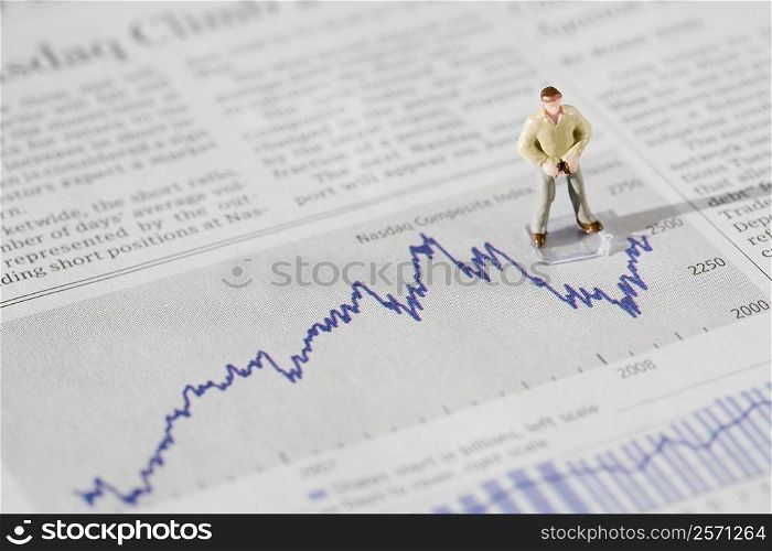 Figurine of a businessman standing on a financial newspaper