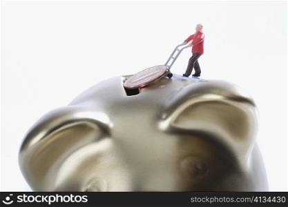 Figurine of a man putting a coin into a piggy bank