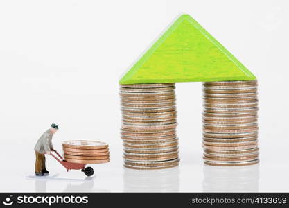 Figurine of a manual worker carrying coins on a wheelbarrow