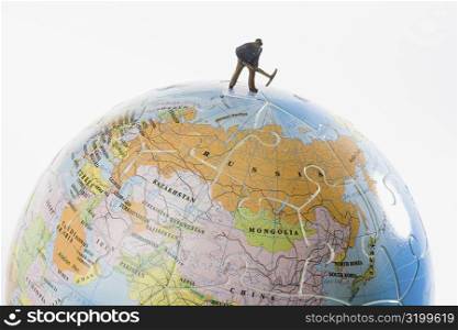 Figurine of a manual worker working on a globe