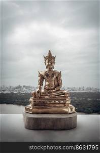 Figurine of Gold Brass Phra Phut Sik Khi Thotsaphon (First Buddha) buddha sculpture statue with nature background. Space for text, Selective focus.
