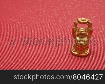 Figurine of laughing and cheerful golden Buddha