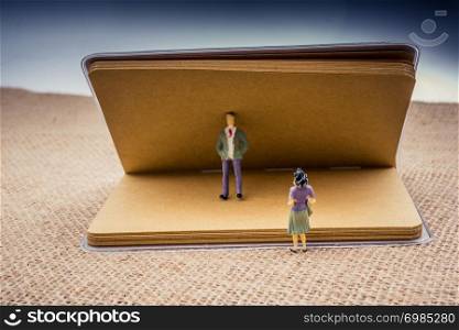 Figurine of man and woman with notebook