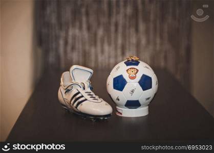 Figurines in the form of football footwear and a ball for game in football and wedding rings.