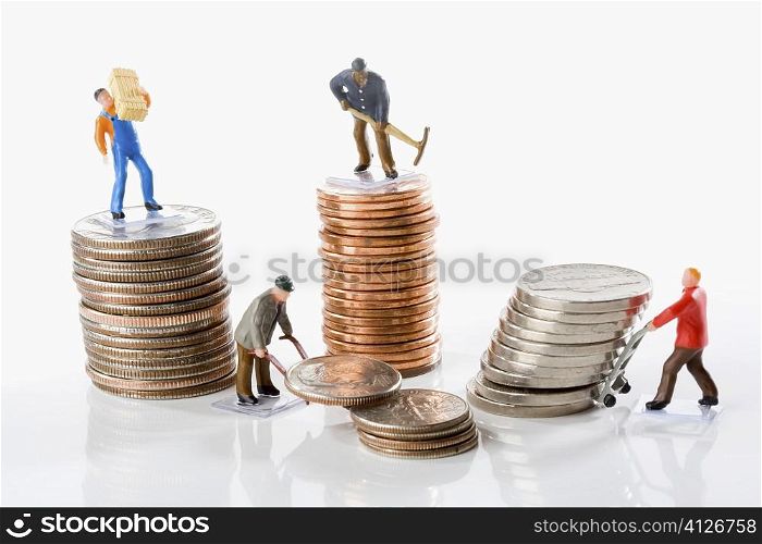 Figurines of manual workers with stacks of coins
