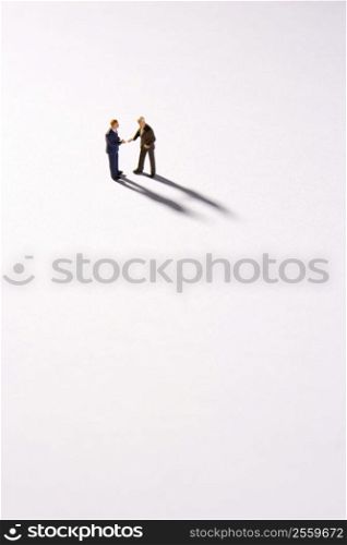 Figurines Of Two Businessmen Shaking Hands