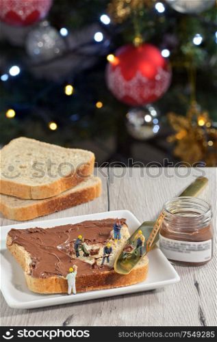 Figurines workers on slice of bread and chocolate cream