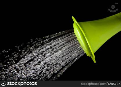 file of green watering can pouring water with high speed shutter isolated on black . green watering can pouring water with high speed shutter isolated on black