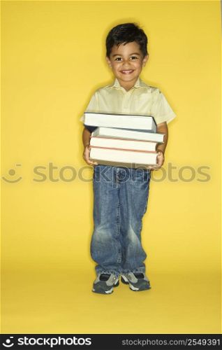 Filipino male child holding stack of books.