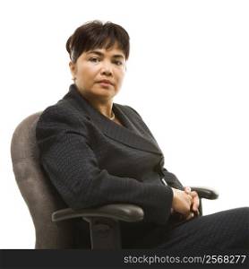 Filipino middle-aged businesswoman sitting in office chair against white background.