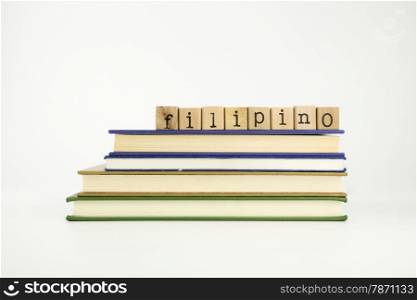 filipino word on wood stamps stack on books, language and conversation concept