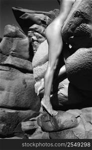 Filipino young nude woman climbing rocks.