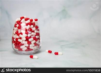 Filled glass with capsules pills for medication.drugs or vitamin,assorted pharmaceutical medicine tablets, in jar, health,business,medication concept with copy space space for text. Filled glass with capsules pills for medication.drugs or vitamin,assorted pharmaceutical medicine tablets, in jar, health,business,medication concept with copy space