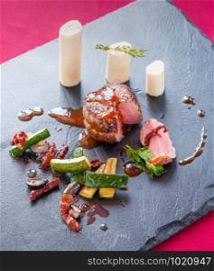 Fillet of beef with zucchini and hearts of palm, on a slate